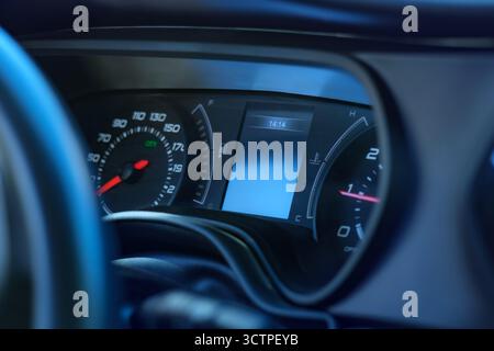 Nahaufnahme eines Armaturenbretts mit Tachometer, Kraftstoffanzeige und Temperaturanzeige. Die beleuchtete Tafel hebt die Fahrzeugtechnik hervor. Stockfoto
