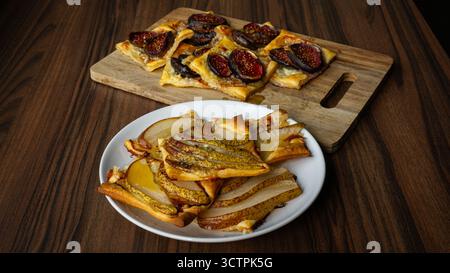 Hausgemachte Blätterteigtorte mit Feigen und Birnen auf Holzoberfläche. Frisch gebackenes Dessert mit Honigglasur, perfekt für Lebensmittelfotografie. Stockfoto