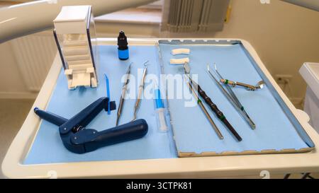 Set zahnärztlicher Instrumente auf blauem sterilem Tablett in der Klinik. Professionelle Geräte für die Mundpflege und zahnärztliche Verfahren. Stockfoto