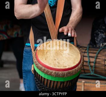 Detail eines Djembe-Drum-Players im dunklen Rücken Stockfoto