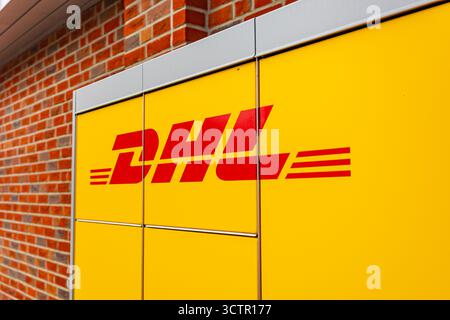 DHL-Firmenlogo auf der automatisierten Self-Service-Verpackungsstation in gelber Farbe der Marke Stockfoto