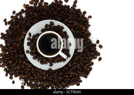 Tasse schwarzen Kaffee umgeben von gerösteten Kaffeebohnen auf weißem Hintergrund. Blick von oben auf ein Konzept für frischen Espresso. Stockfoto