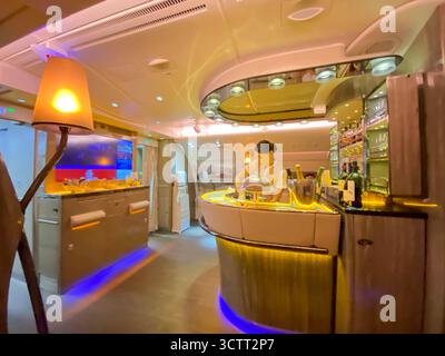 Eine Stewardess, die auf langen Strecken in der exklusiven First und Business Class Onboard Lounge oder in der Inflight Bar auf dem Oberdeck eines Emirates A380 arbeitet Stockfoto