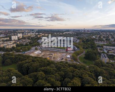 Aus der Vogelperspektive auf ein Stadion, umgeben von üppigen grünen Bäumen und städtischen Gebäuden unter dem Abendhimmel, Malmö, Scania County, Schweden. Stockfoto