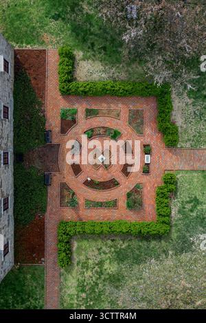 Aus der Vogelperspektive eines symmetrischen roten Backsteingartens mit grünen Hecken und einer kleinen Statue im Zentrum, Richmond, Virginia, USA. Stockfoto
