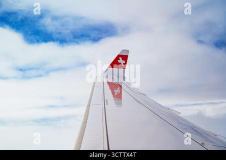 Amsterdam, Niederlande, 29. August 2025. Swiss Air Cross Logo auf der Flügelspitze eines kommerziellen Passagierflugzeugs. Reiseflughöhe, Wolken unten, Fenster Stockfoto
