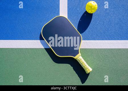 Hochwinkelansicht des Pickleball-Paddels mit Ball auf der Oberfläche des Platzes im Freien Stockfoto