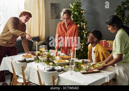 Gruppe junger multiethnischer Freunde, die Weihnachtsessen genießen Stockfoto