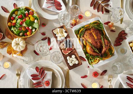 Blick von oben auf den Thanksgiving-Tisch mit gebratenem Huhn und Salat Stockfoto