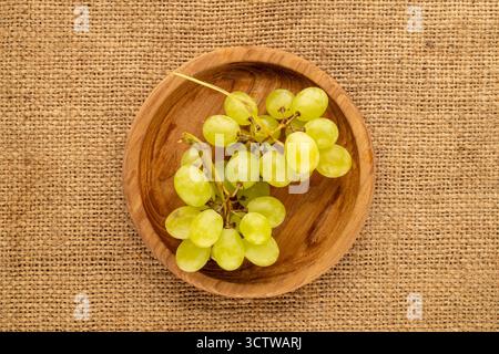 Süße Trauben auf Jute-Tuch, Blick von oben. Stockfoto