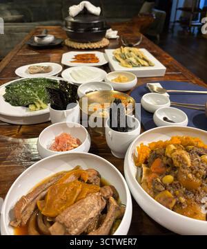 Ein Foto der traditionellen koreanischen Küche in Gyeongju, Südkorea, präsentiert als üppiges Aufstrich mit großen geschmorten Gerichten und einer vielfältigen Auswahl an Banchan wie knusprigem getrocknetem Seegras, blanchiertem grünem Blattgemüse und eingelegtem Rettich. Dieser als Hansang bekannte Speisestil umfasst in der Regel zahlreiche Beilagen, die zu den Hauptgerichten gehören. 2025. Stockfoto