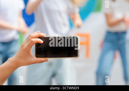 Nahaufnahme der Frauenhand mit Smartphone in öffentlichem Filmvideo Stockfoto