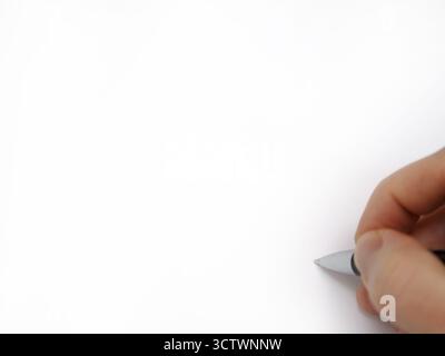 Eine männliche Hand ist dabei, mit einem Tintenstift auf eine leere weiße Oberfläche zu schreiben, mit Platz, um Ihren eigenen Text oder eine Kopie in den meisten Bildbereichen hinzuzufügen. Stockfoto