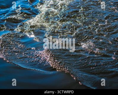 Glitzernde Ozeanwasseroberfläche mit Sonnenlichtreflektionen - abstrakte blaue Meereswellen-Textur für Natur und Meditationsinhalte. Ultrahohe Auflösung Stockfoto