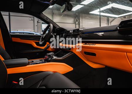 Innenausstattung von Lamborghini Urus mit Details aus Leder in Orange und Schwarz Stockfoto