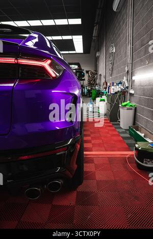 Nahaufnahme von Lila Lamborghini Urus hinten in Garage mit kariertem Boden Stockfoto