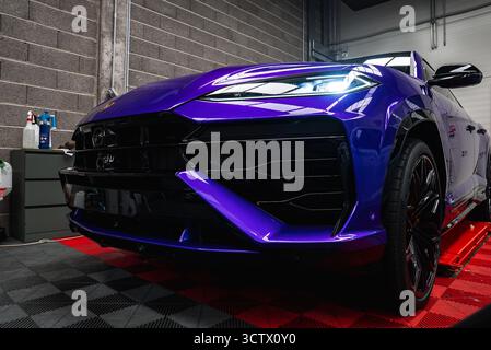 Nahaufnahme von Lila Lamborghini Urus auf rot-schwarz kariertem Boden Stockfoto