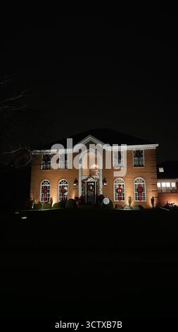 Chicago, Illinois, USA - 25. Dezember 2024: Festliches Backsteinhaus in Chicago bei Nacht, beleuchtet von Lichtern und warmer Weihnachtsdekoration. Stockfoto