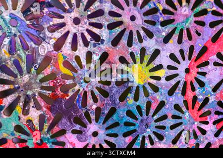 Buntes abstraktes Blumensternmuster auf einer Metallausschnittstruktur. Lebendiger mehrfarbiger grundiger Hintergrund mit Farbspritzer-Effekt. Stockfoto