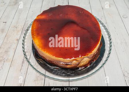 Klassische Karamelltorte mit cremiger Dulce de leche-Textur, verziert mit dünnen Schokoladenflocken und gehackten gerösteten Haselnüssen Stockfoto
