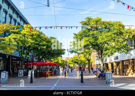 Shopper im Church Street Marketplace in Burlington, Vermont, einer belebten Fußgängerzone mit Geschäften, Cafés im Freien und Straßenverkäufern. Stockfoto