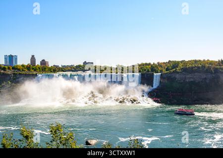 Ein pulsierender Panoramablick auf die American Falls bei den Niagara Falls, New York, mit der berühmten Rainbow Bridge, die die USA und Kanada in der verbindet Stockfoto