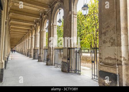Frankreich, Paris. Kolonnade im Palais Royal Komplex mit Blick auf den Jardin du Palais Royal. Stockfoto