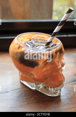 Lebendige Farben, ices Thai Tee, gemischt mit dunkler Schokolade in skelettförmigem Glas Stockfoto