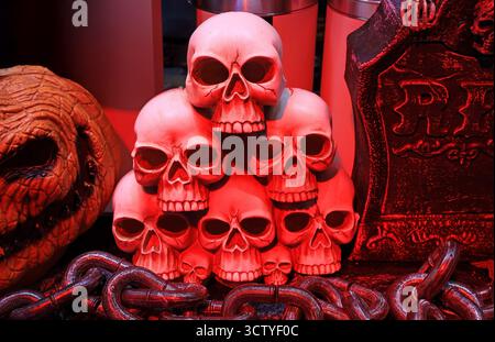 Gruselige Halloween-Dekoration mit einem Haufen beleuchteter Schädel und Grabstein Stockfoto
