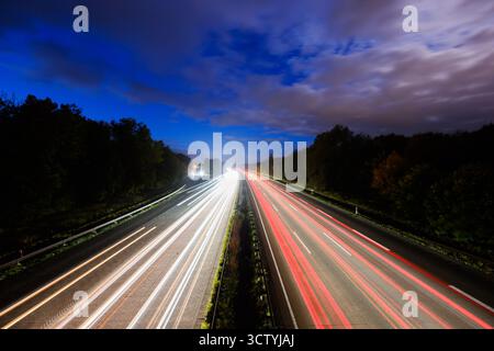 Hannover, Deutschland. Oktober 2025. Die Autos fahren am frühen Morgen auf der Autobahn A7 (Langzeitbelichtung). Vertreter aus Politik, Herstellern und Zulieferern, Verbänden und Gewerkschaften sowie der bundesländer mit der Automobilindustrie kommen zu einem sogenannten Autogipfel zusammen. Quelle: Julian Stratenschulte/dpa/Alamy Live News Stockfoto