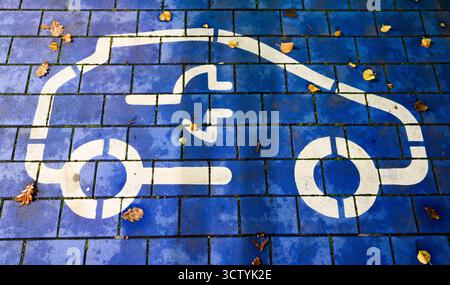 Hannover, Deutschland. Oktober 2025. Ein Symbol kennzeichnet einen Parkplatz für Elektroautos an einer öffentlichen Schnellladestelle. Vertreter aus Politik, Herstellern und Zulieferern, Verbänden und Gewerkschaften sowie aus den ländern und der Automobilindustrie kommen zu einem sogenannten Autogipfel zusammen. Quelle: Julian Stratenschulte/dpa/Alamy Live News Stockfoto
