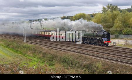Als Dampflokomotive wurde die Lokomotive Duke of Gloucester 7100 eingesetzt. Es zieht Passagierbusse ab, Rauch hinterher mit Platz für Text Stockfoto