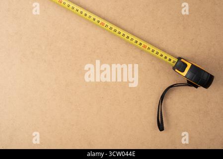 Maßband auf Holzoberfläche. Konzept der Genauigkeit, Präzision, Konstruktion, Renovierung, Planung, Heimwerkerprojekte, Tischlerei und professionelle Werkzeuge f Stockfoto