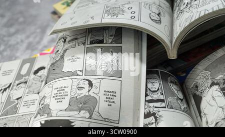 South Kalimantan, Indonesien - 12 08 2023 : Ein Stapel japanischer Comics oder Manga mit dem Titel Giant Killing mit einer offenen Seite auf grauem Hintergrund mit Stockfoto