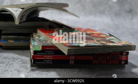 South Kalimantan, Indonesien - 12 08 2023 : Ein Stapel japanischer Comics oder Mangas mit dem Titel Giant Killing auf grauem Hintergrund mit Betontextur Stockfoto