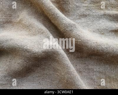 Die ländliche Beschaffenheit des Sacktuchs. Hintergrund aus sehr groben, groben Geweben aus Flachs, Jute oder Hanf. Leinenbeutelmaterial. Konstruktionselement. Abfeuern und Stockfoto