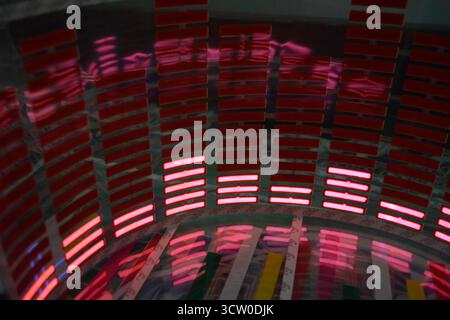 Roter, leuchtender Plastikaufkleber in Form eines echten Equalizers, der zur Musik aufblitzt. Viele rot leuchtende Quadrate auf weichem Kunststoffhintergrund, lebhaft, Stockfoto