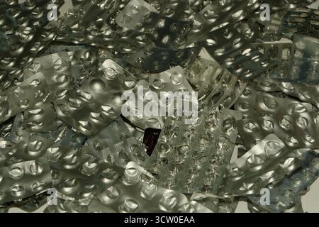 Ein Stapel gebrauchter und leerer Aluminium-Pillen-Blisterpackungen - übermäßiger Gebrauch von Pillen kann gefährlich sein. Stockfoto