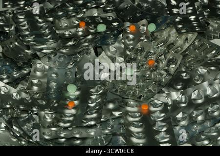 Ein Stapel gebrauchter und leerer Tabletten-Blisterpackungen - Proben Sie Orangenpillen - zu viel Gebrauch von Pillen kann gefährlich sein. Stockfoto