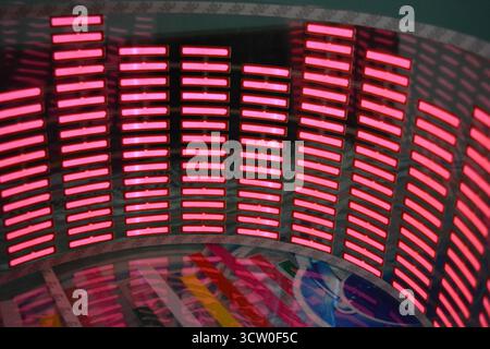 Roter, leuchtender Plastikaufkleber in Form eines echten Equalizers, der zur Musik aufblitzt. Viele rot leuchtende Quadrate auf weichem Kunststoffhintergrund, lebhaft, Stockfoto