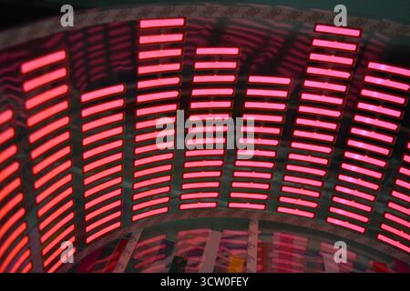 Roter, leuchtender Plastikaufkleber in Form eines echten Equalizers, der zur Musik aufblitzt. Viele rot leuchtende Quadrate auf weichem Kunststoffhintergrund, lebhaft, Stockfoto