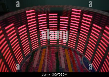 Roter, leuchtender Plastikaufkleber in Form eines echten Equalizers, der zur Musik aufblitzt. Viele rot leuchtende Quadrate auf weichem Kunststoffhintergrund, lebhaft, Stockfoto