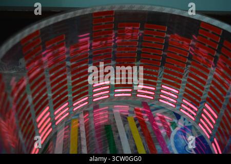 Roter, leuchtender Plastikaufkleber in Form eines echten Equalizers, der zur Musik aufblitzt. Viele rot leuchtende Quadrate auf weichem Kunststoffhintergrund, lebhaft, Stockfoto