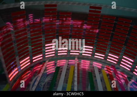 Roter, leuchtender Plastikaufkleber in Form eines echten Equalizers, der zur Musik aufblitzt. Viele rot leuchtende Quadrate auf weichem Kunststoffhintergrund, lebhaft, Stockfoto