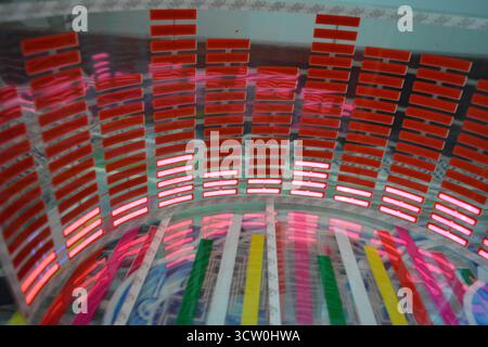 Roter, leuchtender Plastikaufkleber in Form eines echten Equalizers, der zur Musik aufblitzt. Viele rot leuchtende Quadrate auf weichem Kunststoffhintergrund, lebhaft, Stockfoto