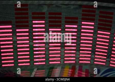 Roter, leuchtender Plastikaufkleber in Form eines echten Equalizers, der zur Musik aufblitzt. Viele rot leuchtende Quadrate auf weichem Kunststoffhintergrund, lebhaft, Stockfoto