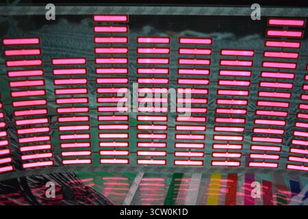 Roter, leuchtender Plastikaufkleber in Form eines echten Equalizers, der zur Musik aufblitzt. Viele rot leuchtende Quadrate auf weichem Kunststoffhintergrund, lebhaft, Stockfoto