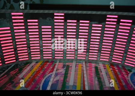 Roter, leuchtender Plastikaufkleber in Form eines echten Equalizers, der zur Musik aufblitzt. Viele rot leuchtende Quadrate auf weichem Kunststoffhintergrund, lebhaft, Stockfoto