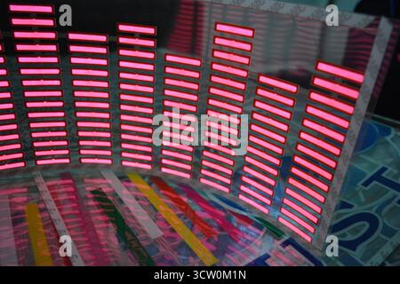 Roter, leuchtender Plastikaufkleber in Form eines echten Equalizers, der zur Musik aufblitzt. Viele rot leuchtende Quadrate auf weichem Kunststoffhintergrund, lebhaft, Stockfoto