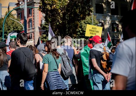 Ein Demonstrant hält während der Demonstration ein Plakat. Tausende von Menschen versammelten sich in Rom zu einem nationalen Protest pro Palästina am 2. Jahrestag des Beginns des Völkermords in Gaza. Stockfoto
